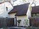 Charming townhouse featuring light stucco walls, a brown shingle roof, and a private fenced entrance at 12611 Touchton Dr # 122, Tampa, FL 33617