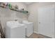 Bright laundry room featuring a washer and dryer, wire shelf for storage, and tile floors at 12647 Retreat Pl, Spring Hill, FL 34610