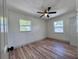 Inviting bedroom with wood-look floors, ceiling fan, and ample natural light from two windows at 1312 Tuscola St, Clearwater, FL 33756