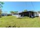 Spacious backyard featuring a well-maintained lawn, white fence, storage shed, and covered patio at 13596 Croft N Dr, Largo, FL 33774