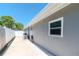 Exterior of the home showcasing the siding, patio, and window with manicured landscaping at 13596 Croft N Dr, Largo, FL 33774