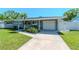 Charming single-story home featuring a well-manicured lawn and a private driveway leading to an attached garage at 13596 Croft N Dr, Largo, FL 33774