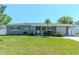 Charming single-story home with well-maintained lawn and a welcoming front entrance and freshly painted gray exterior at 13596 Croft N Dr, Largo, FL 33774