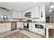 Bright kitchen features white cabinets, granite countertops, stainless steel appliances, and hardwood floors at 13596 Croft N Dr, Largo, FL 33774