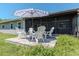 Outdoor patio featuring chairs and umbrella, ideal for relaxation and located adjacent to the screened porch at 13596 Croft N Dr, Largo, FL 33774