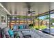 Screened-in patio with comfortable seating and ceiling fan overlooking a fenced backyard at 13596 Croft N Dr, Largo, FL 33774