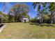 Wide-open backyard features a shed, a well-manicured lawn, and mature trees at 1433 Park N St, St Petersburg, FL 33710