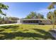 Expansive backyard view of a charming single-story home with a screened in porch and lush lawn at 1433 Park N St, St Petersburg, FL 33710