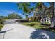 Exterior view of a one story home with a screened in porch, lush green lawn and long driveway at 1433 Park N St, St Petersburg, FL 33710