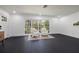 Bright living room with two armchairs, dark hardwood floors, and a large window overlooking the landscape at 1433 Park N St, St Petersburg, FL 33710