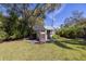 Wooden shed with double doors in backyard amongst mature trees at 1433 Park N St, St Petersburg, FL 33710