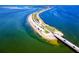 Stunning aerial view of a coastal road surrounded by crystal-clear blue waters, offering scenic community access at 1521 San Helen Dr, Dunedin, FL 34698