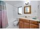 Bright bathroom with vanity, bathtub, and a floral shower curtain at 1521 San Helen Dr, Dunedin, FL 34698