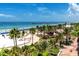 Expansive beach view with palm trees, clear water, and a pier, offering a vibrant community atmosphere at 1521 San Helen Dr, Dunedin, FL 34698