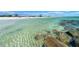 Stunning beach view with crystal clear water and scattered rocks along the shoreline at 1521 San Helen Dr, Dunedin, FL 34698