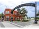 A view of a street in downtown Dunedin, featuring a brick building with a 'Defending Freedom' sign at 1521 San Helen Dr, Dunedin, FL 34698