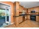 Updated kitchen with natural wood cabinets, granite countertops, and door to outside patio at 1521 San Helen Dr, Dunedin, FL 34698