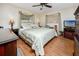 Cozy main bedroom with hardwood flooring, a ceiling fan, and large windows at 1521 San Helen Dr, Dunedin, FL 34698