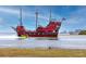 A striking pirate ship with tourists sails near the shore with views of the city skyline in the distance at 1521 San Helen Dr, Dunedin, FL 34698