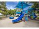 Colorful community playground featuring slides, climbing structures, and sun shades near the water at 1521 San Helen Dr, Dunedin, FL 34698