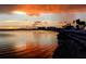Scenic sunset over the water, with buildings and palm trees silhouetted against the colorful sky at 1521 San Helen Dr, Dunedin, FL 34698