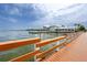 Picturesque waterfront restaurant and pier with a charming wooden railing extending into the blue water at 1521 San Helen Dr, Dunedin, FL 34698