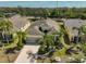 Aerial view of a lovely home with mature palm trees and a water view at 1647 Emerald Dunes Dr, Sun City Center, FL 33573
