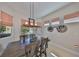 Dining room with modern lighting fixture, wine racks, and sunlit windows with fabric shades at 1647 Emerald Dunes Dr, Sun City Center, FL 33573