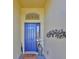Charming blue front door with decorative accents and a 'welcome' mat at 1647 Emerald Dunes Dr, Sun City Center, FL 33573