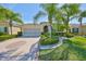 Charming single-story home features tropical landscaping and a patterned driveway at 1647 Emerald Dunes Dr, Sun City Center, FL 33573