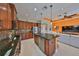 Gourmet kitchen with granite countertops, stainless steel appliances, and breakfast bar overlooking the living room at 1647 Emerald Dunes Dr, Sun City Center, FL 33573
