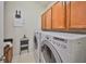 Bright laundry room with front loading washer, dryer, cabinetry, and convenient shelving at 1647 Emerald Dunes Dr, Sun City Center, FL 33573