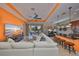 Bright, open-concept living space featuring a large white sectional, kitchen bar and sliding glass doors to the patio at 1647 Emerald Dunes Dr, Sun City Center, FL 33573