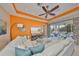 Bright living room features a ceiling fan, an orange accent wall, and seamless access to the outdoor space at 1647 Emerald Dunes Dr, Sun City Center, FL 33573