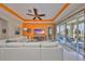 Spacious living room boasting an orange accent wall, ceiling fan and sliding glass doors to the outdoor space at 1647 Emerald Dunes Dr, Sun City Center, FL 33573