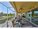 Screened outdoor space with ceiling fans, grill, television, and comfortable seating areas at 1647 Emerald Dunes Dr, Sun City Center, FL 33573
