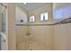 Modern walk-in shower features neutral tile, mosaic accents, and recessed shelving in this bathroom at 1647 Emerald Dunes Dr, Sun City Center, FL 33573