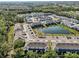 Aerial view of a community with multiple pools, water views and landscaping at 16646 Maude Dr, Wimauma, FL 33598