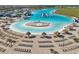 The aerial view showcases the white sandy beach, the crystal blue lagoon, and the numerous lounge chairs at 16646 Maude Dr, Wimauma, FL 33598