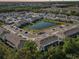 Aerial view of a residential community, showing homes, landscaping, and pond at 16646 Maude Dr, Wimauma, FL 33598
