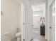 Downstairs bathroom with a toilet and a glimpse into the entrance hall at 16646 Maude Dr, Wimauma, FL 33598
