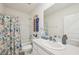 Bathroom featuring a tub shower with vibrant curtains and a single sink vanity at 16646 Maude Dr, Wimauma, FL 33598