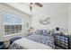 Cozy bedroom featuring a bright window and a bed with patterned blue and white linens at 16646 Maude Dr, Wimauma, FL 33598