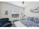 Charming bedroom featuring a bright window and a bed with patterned blue and white linens at 16646 Maude Dr, Wimauma, FL 33598