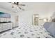 Spacious bedroom with stylish bedding, ceiling fan, and views of the ensuite bathroom at 16646 Maude Dr, Wimauma, FL 33598