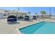 The community pool is surrounded by lounge seating, umbrellas, and a poolside bar in a tropical paradise at 16646 Maude Dr, Wimauma, FL 33598