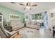 Cozy living room featuring comfortable seating, coastal-themed decor, and a large sliding glass door at 16646 Maude Dr, Wimauma, FL 33598
