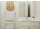 A minimalist bathroom featuring a marble countertop, decorative wall hanging, and neutral color palette at 18453 Serene Lake Loop, Lutz, FL 33548