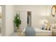 Bright bedroom featuring a cozy bed, closet with sliding doors, and a calming tropical plant at 18453 Serene Lake Loop, Lutz, FL 33548