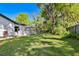 Expansive backyard showcasing a lush lawn and a screened-in pool, offering ample space for outdoor activities at 18846 Tracer Dr, Lutz, FL 33549